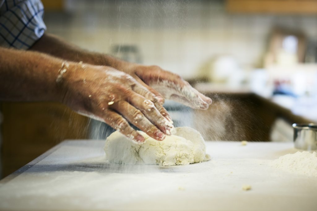chef kneading dough flour